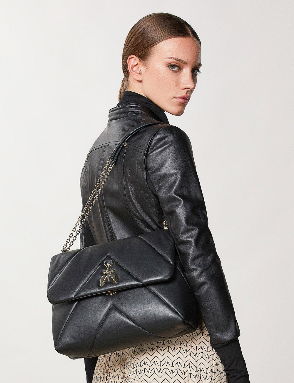 Borsa in pelle nera trapuntata con chiusura ape metallica e tracolla a catena