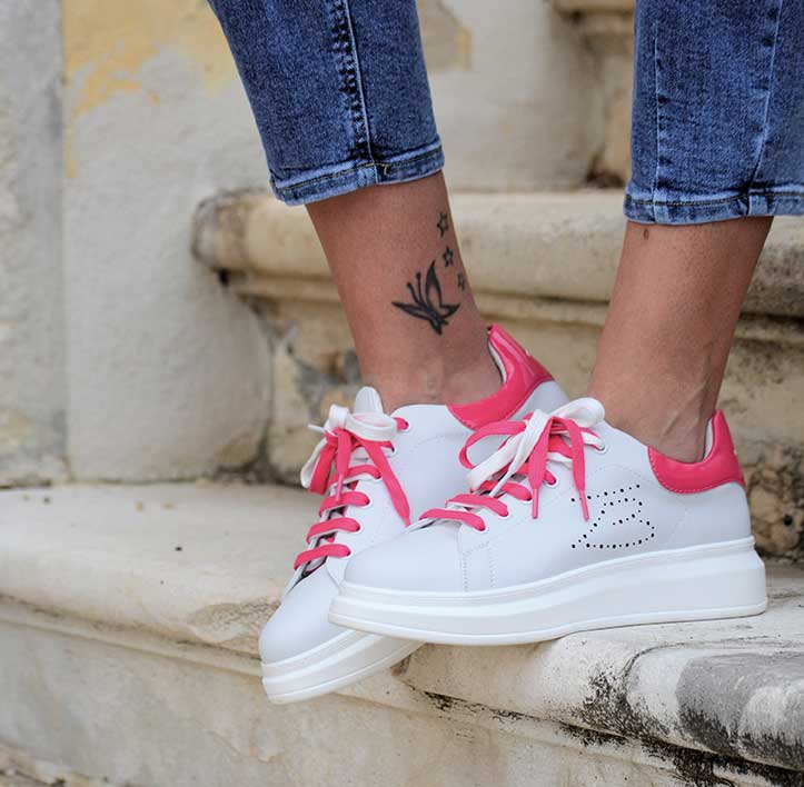 Sneakers bianche con accenti rosa vivaci su lacci, linguetta e suola