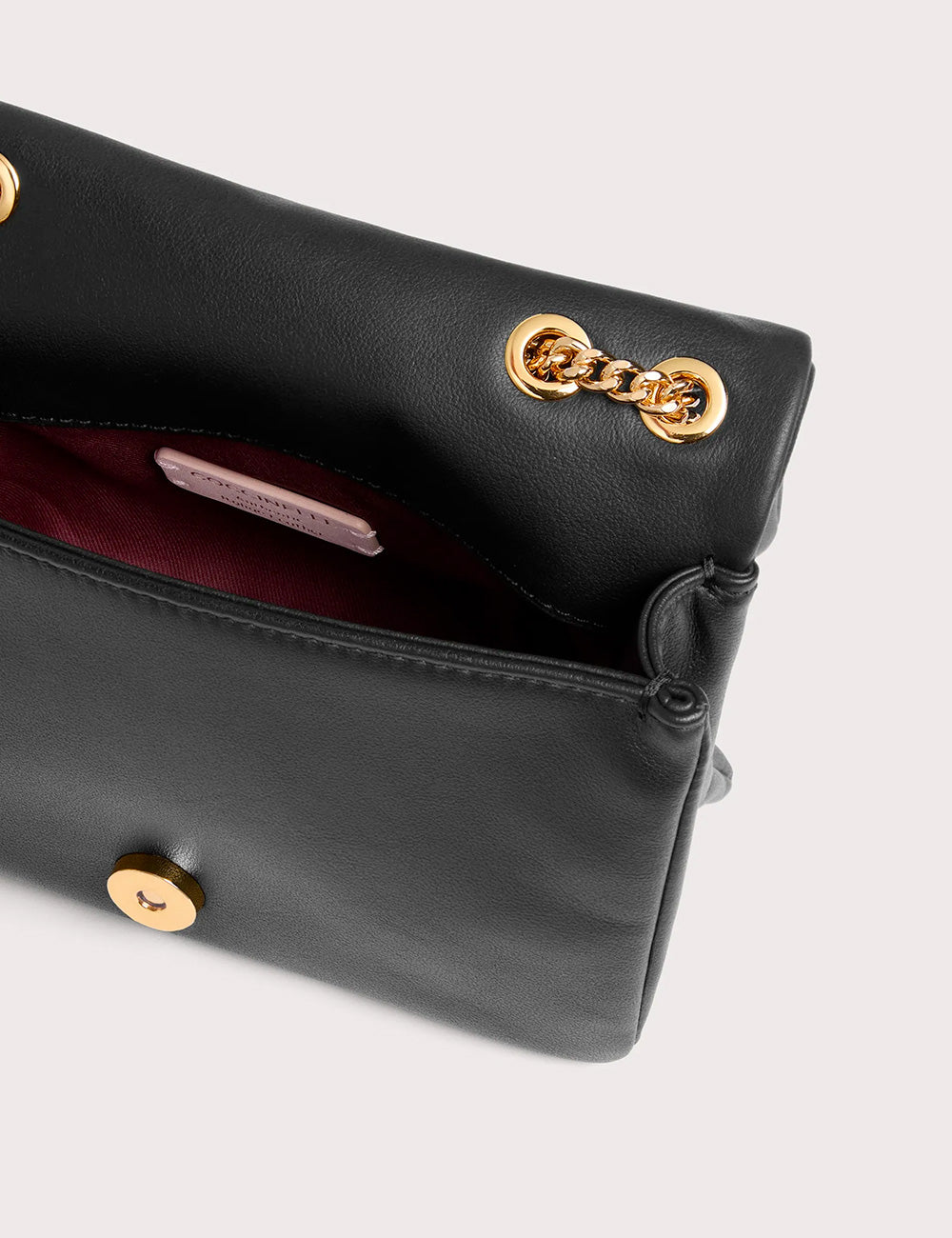 Borsa Coccinelle Dulse Mini Noir in pelle nera con hardware oro e fodera bordeaux