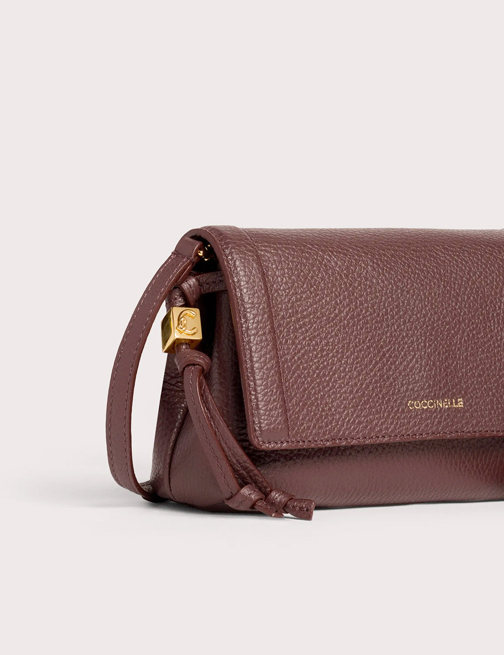 Coccinelle thess mini berry borsa a tracolla in pelle martellata bordeaux con chiusura logo oro e dettaglio di tracolla intrecciata