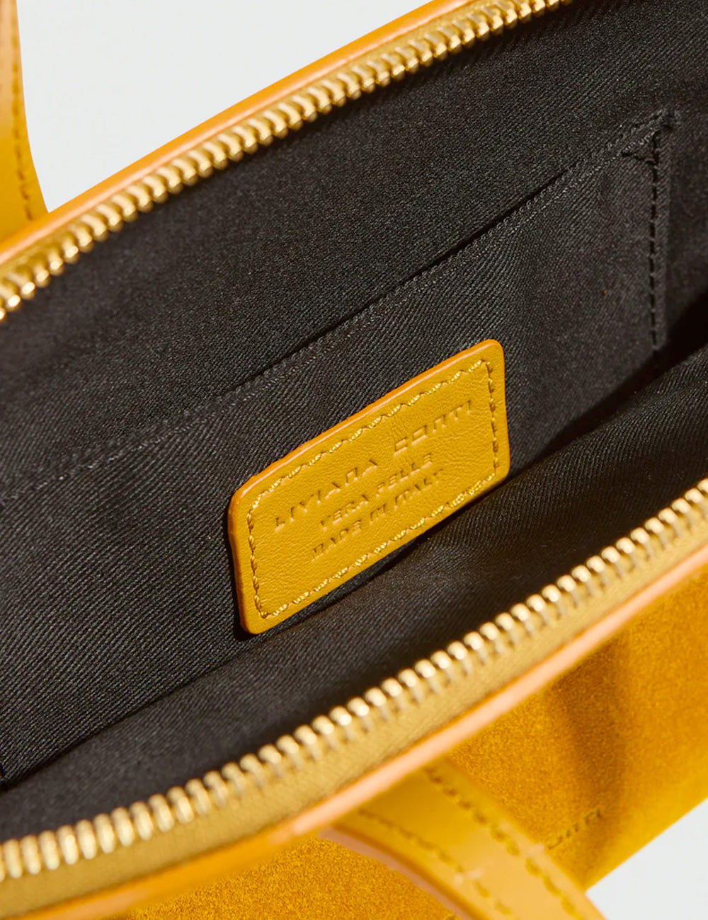 Patch in pelle giallo senape con logo inciso cucito allinterno nero della handbag liviana conti lucille ocra