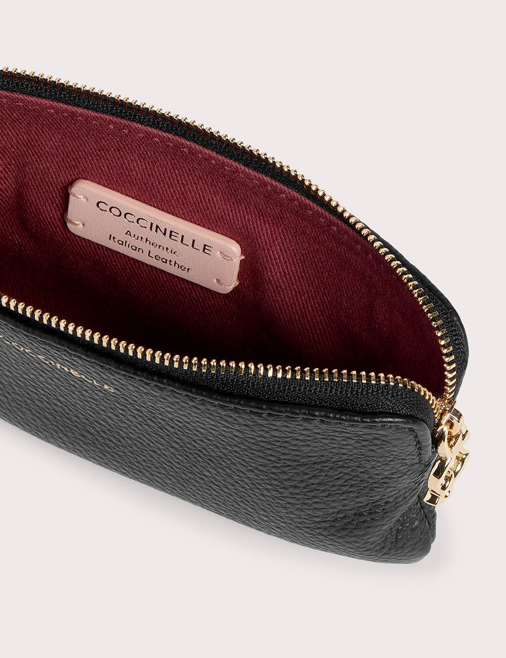 Pochette coccinelle c-me softy small noir in pelle nera testurizzata con cerniera oro e fodera interna borgogna