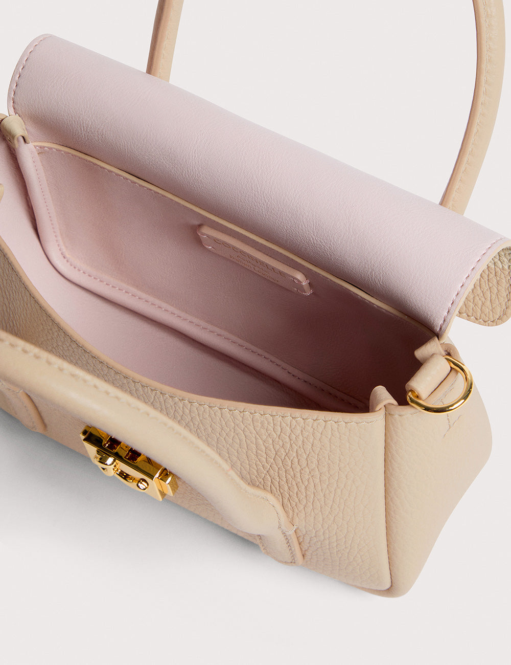 Borsa Coccinelle C-Me Lock Sandshell in pelle rosa cipria con texture esterna e chiusura dorata