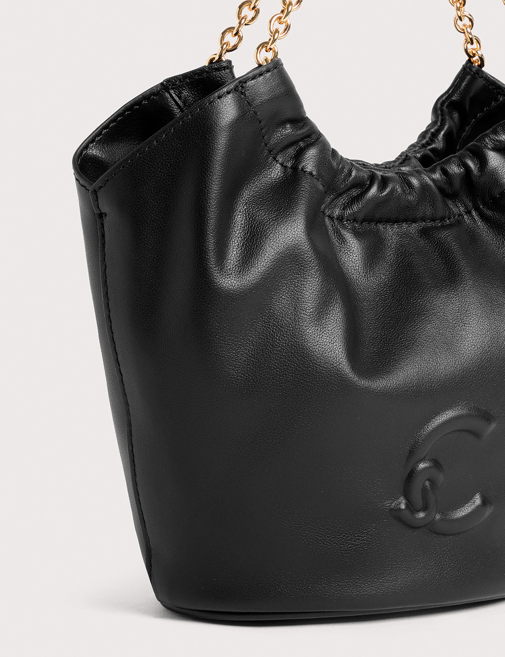 Borsa a secchiello Coccinelle Smash Mini Noir in pelle nera con catena dorata e logo embossato