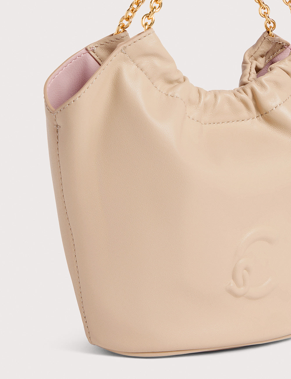 Borsa a secchiello Coccinelle Smash Mini in sandshell beige, pelle con catena oro e logo