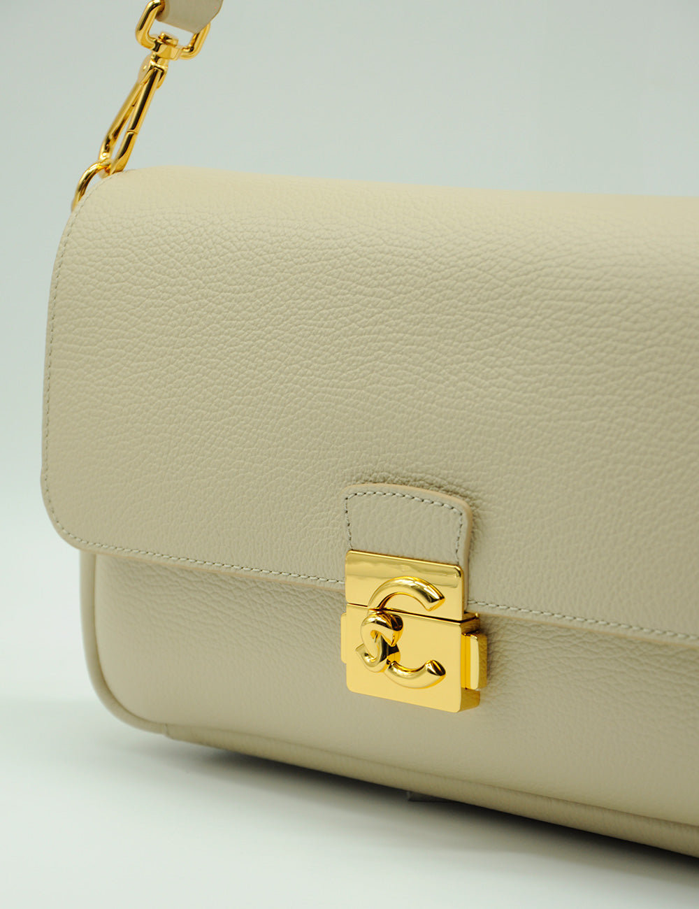 Borsa in pelle color crema Coccinelle C-Me Lock Large Sandshell con chiusura logo cc oro e tracolla catena abbinata