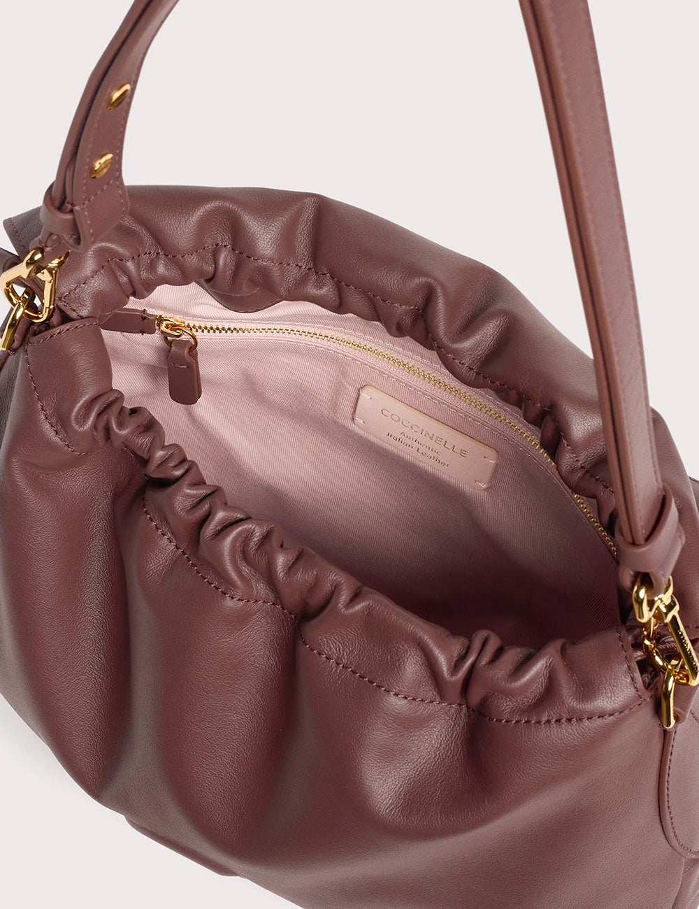 Coccinelle lidia small berry una borsa in morbida pelle color lilla con dettagli dorati e design arricciato