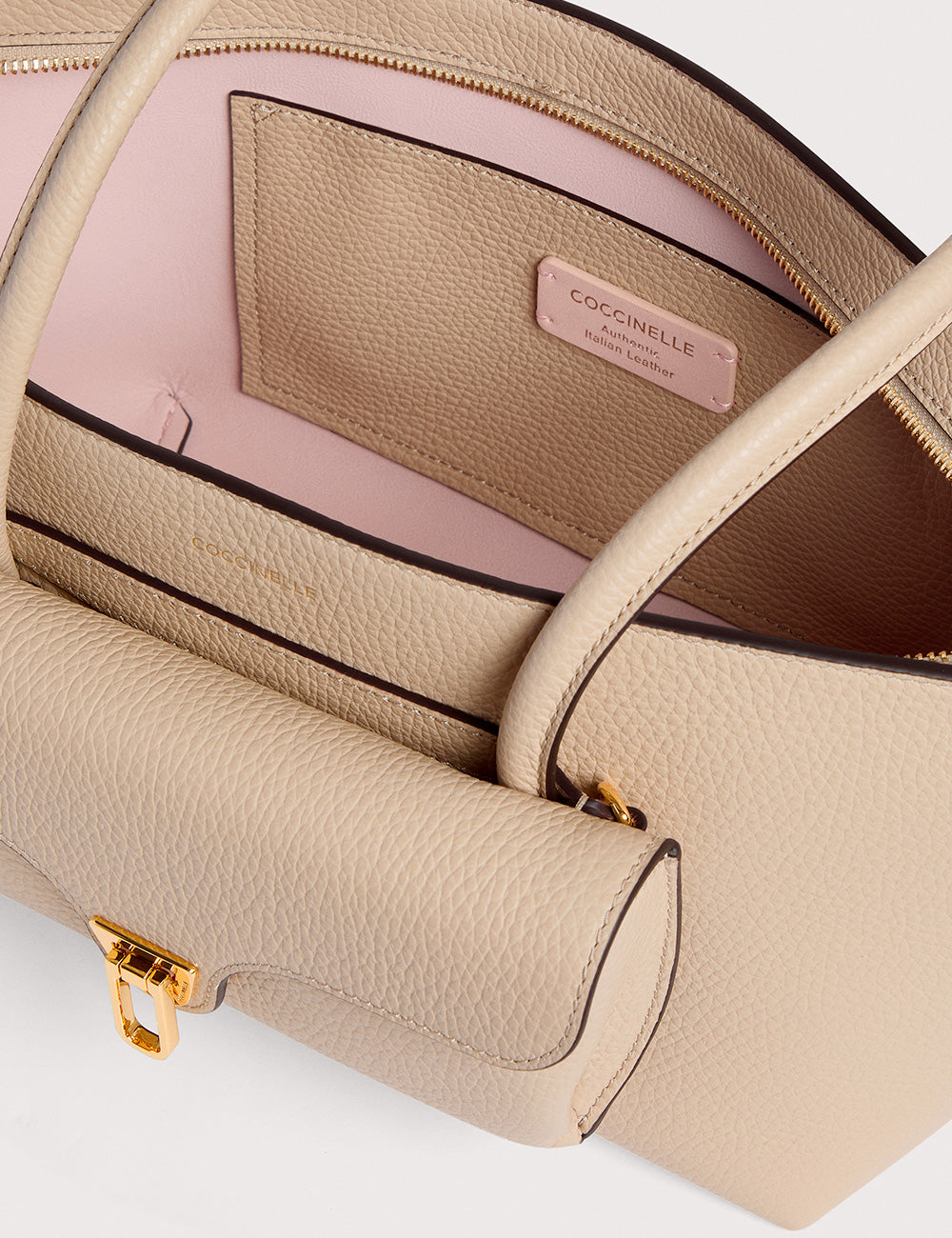 Borsa Coccinelle Double Beat Sandshell in pelle beige testurizzata con hardware dorato e fodera rosa