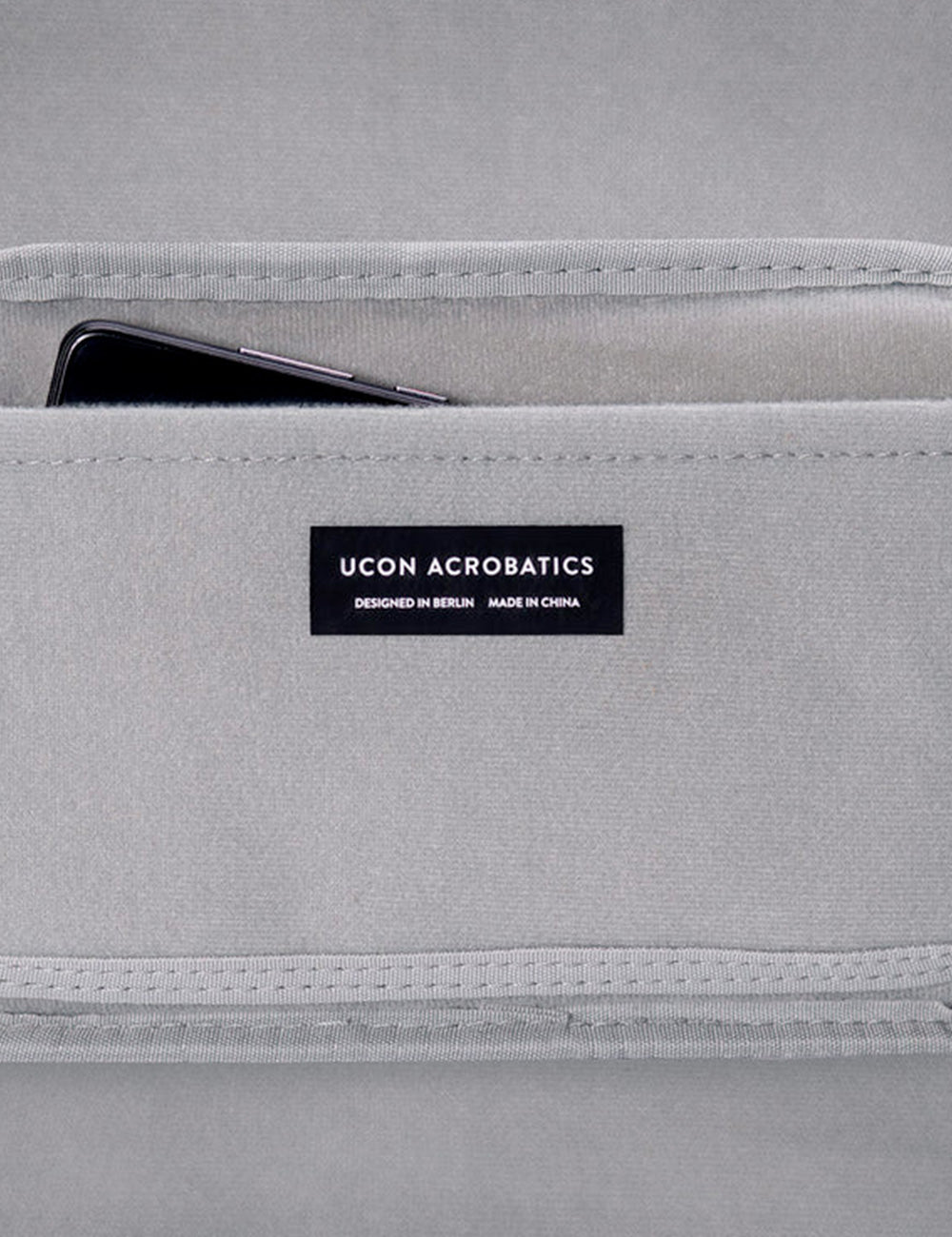 Gray fabric laptop sleeve with subtle stitching and black ucon acrobatics label from the jona aloe hibiscus collection