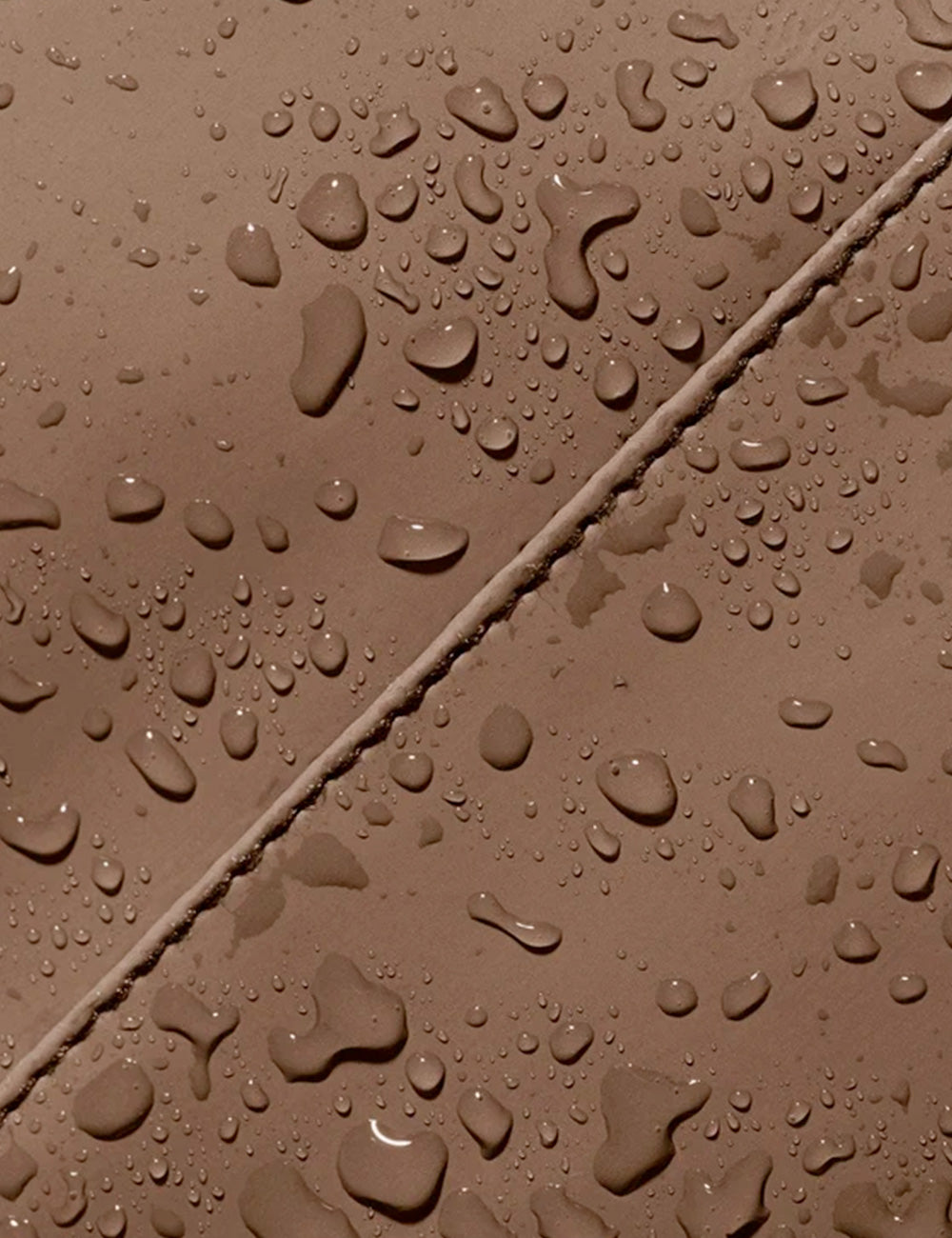Superficie marrone con pioggia d’acqua su zaino ucon acrobatics jona infinity chestnut in tessuto resistente